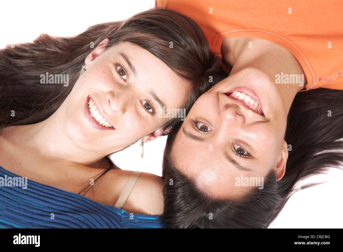 schöne weibliche Freunde liegen auf dem Boden Kopf an Kopf Stockfoto
