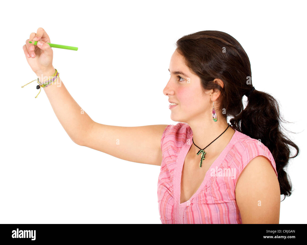 junge Frau, die etwas auf einer imaginären Glasscheibe vor ihr mit einem hellen grünen Bleistift Zeichnung Stockfoto