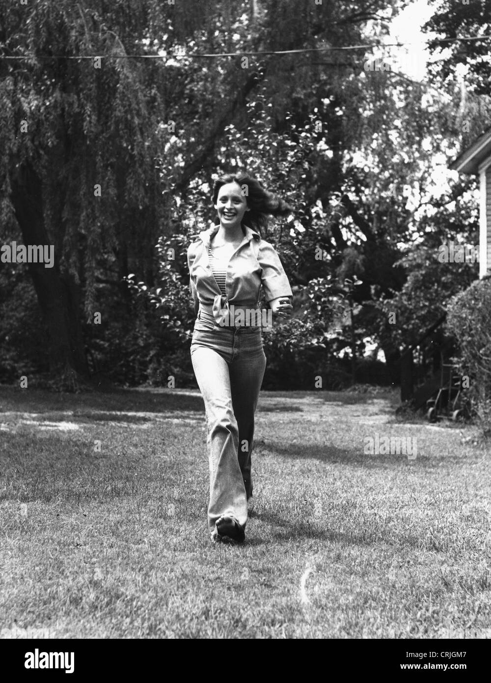 Junge Frau, die zu Fuß in der Wiese Stockfoto