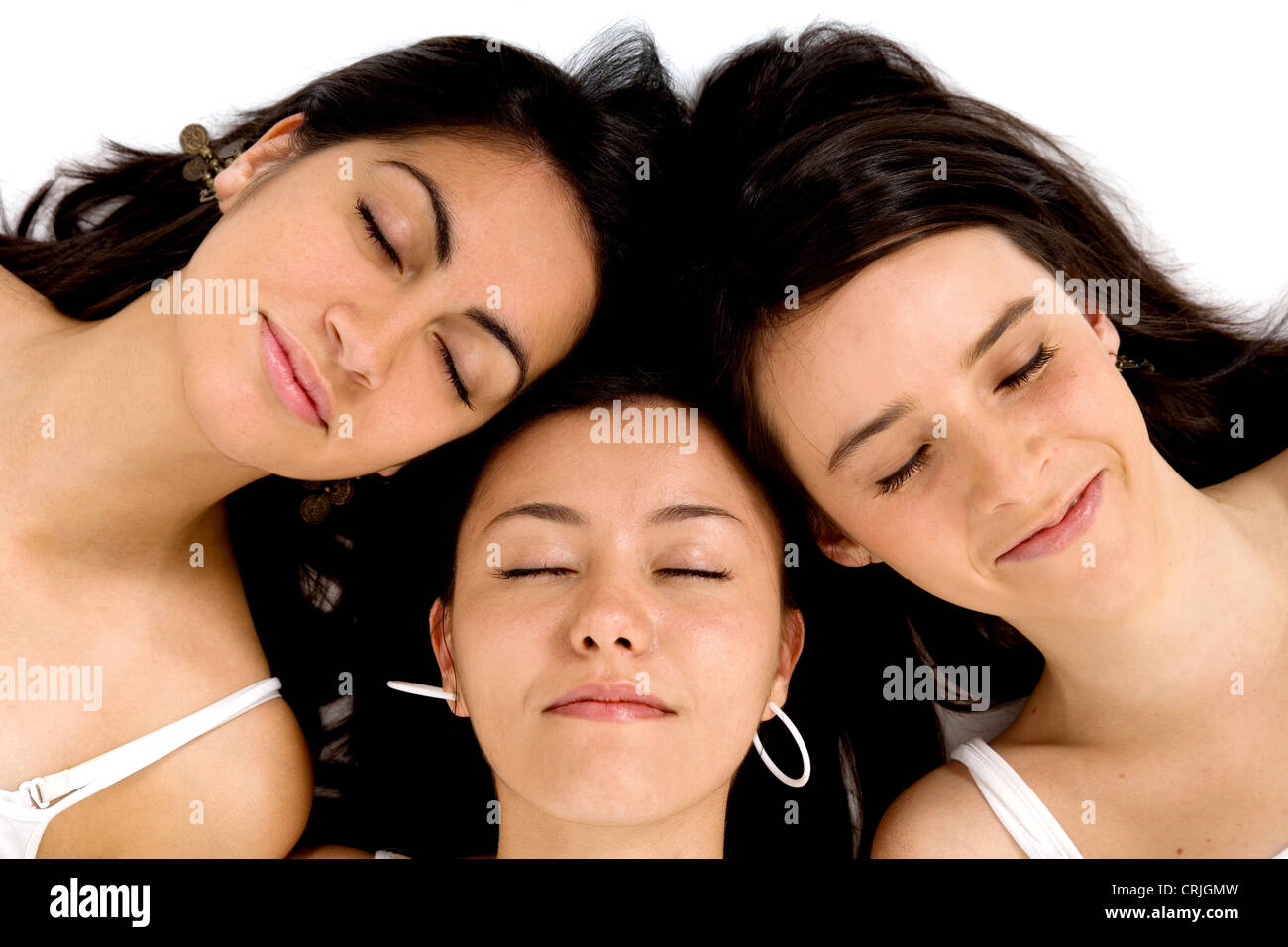 drei Freundinnen, die zusammen mit dem Kopf auf dem Boden schlafen Stockfoto
