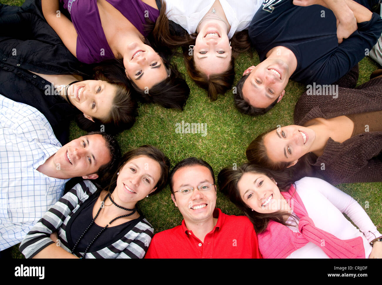 Freundeskreis glücklich lächelnd mit Köpfe zusammen auf den Boden Stockfoto
