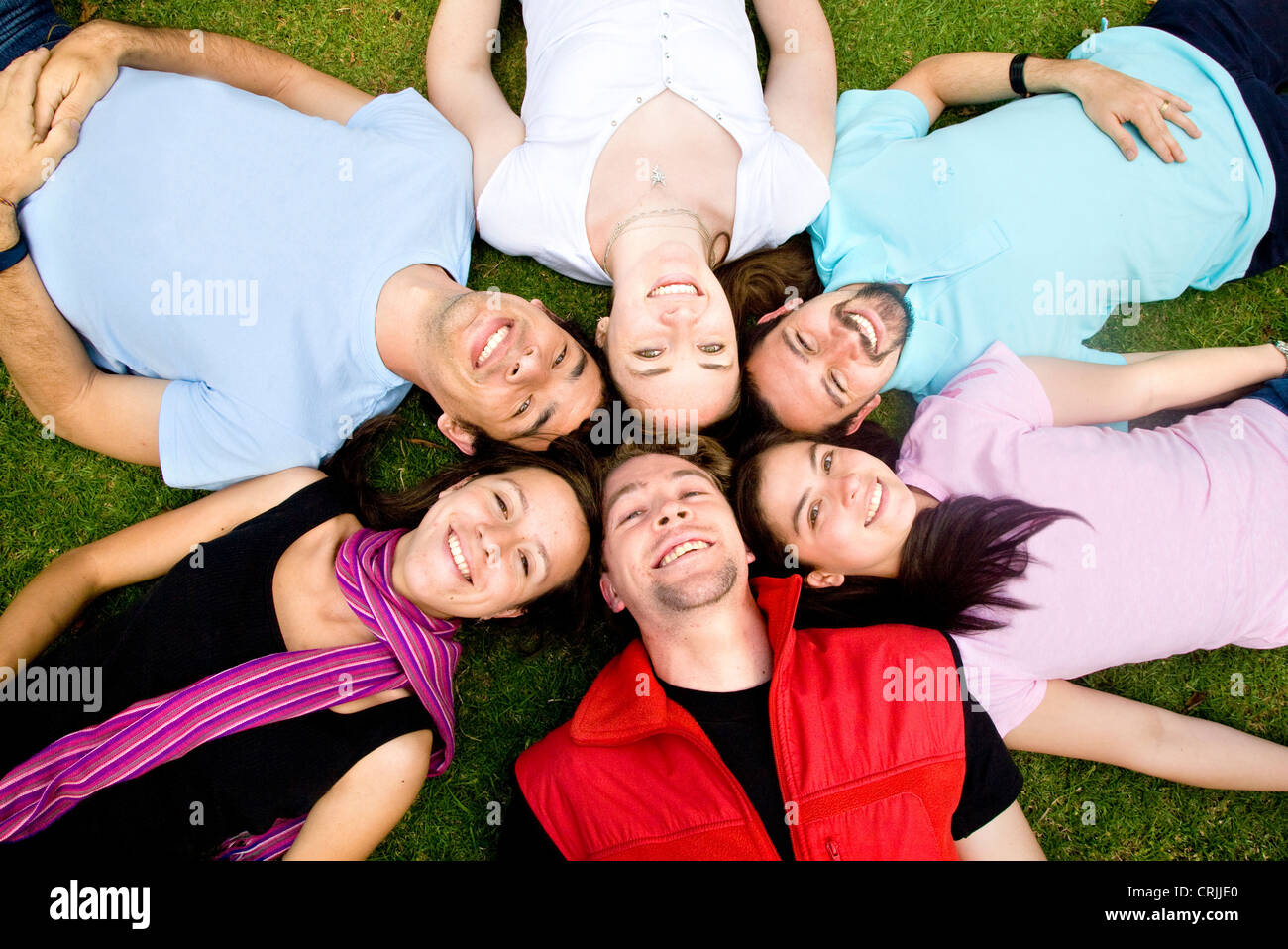 Freundeskreis glücklich lächelnd mit Köpfe zusammen auf den Boden Stockfoto