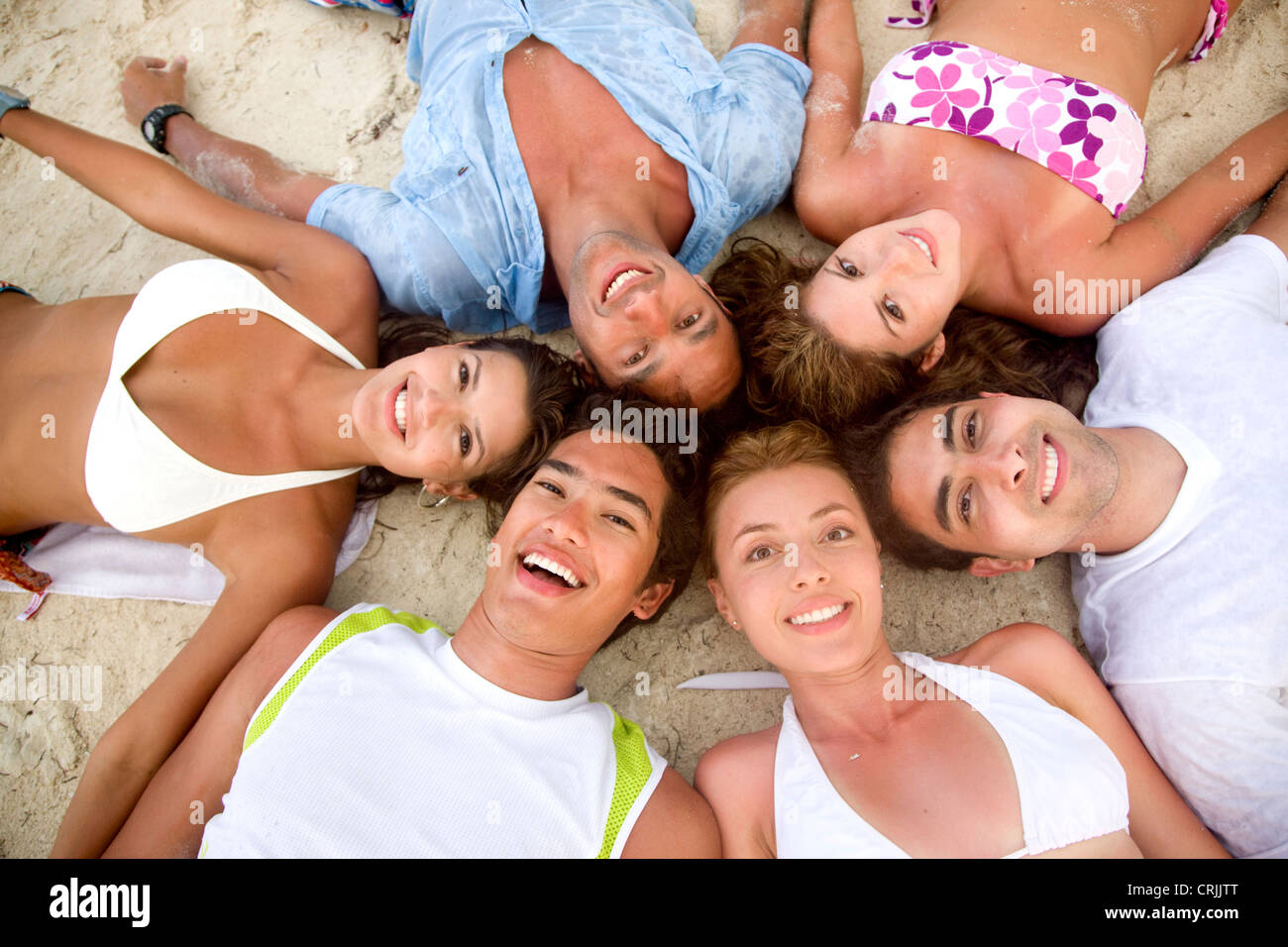 Glücklich lächelnd am Strand Freundeskreis Stockfoto