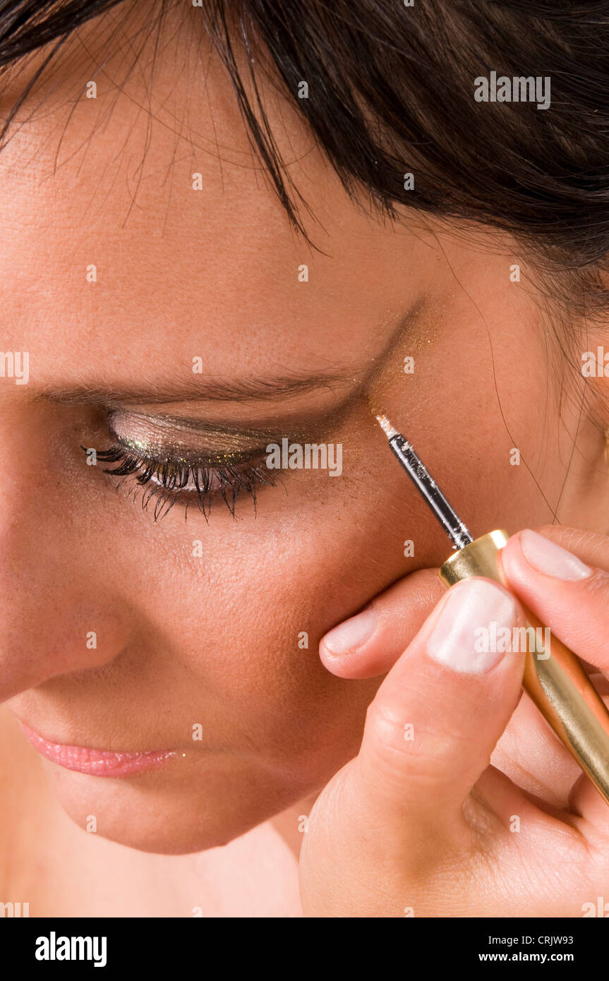 Brünette junge Frau, die eine auffällige Augen Make Up, die an durch eine Kosmetikerin Stockfoto