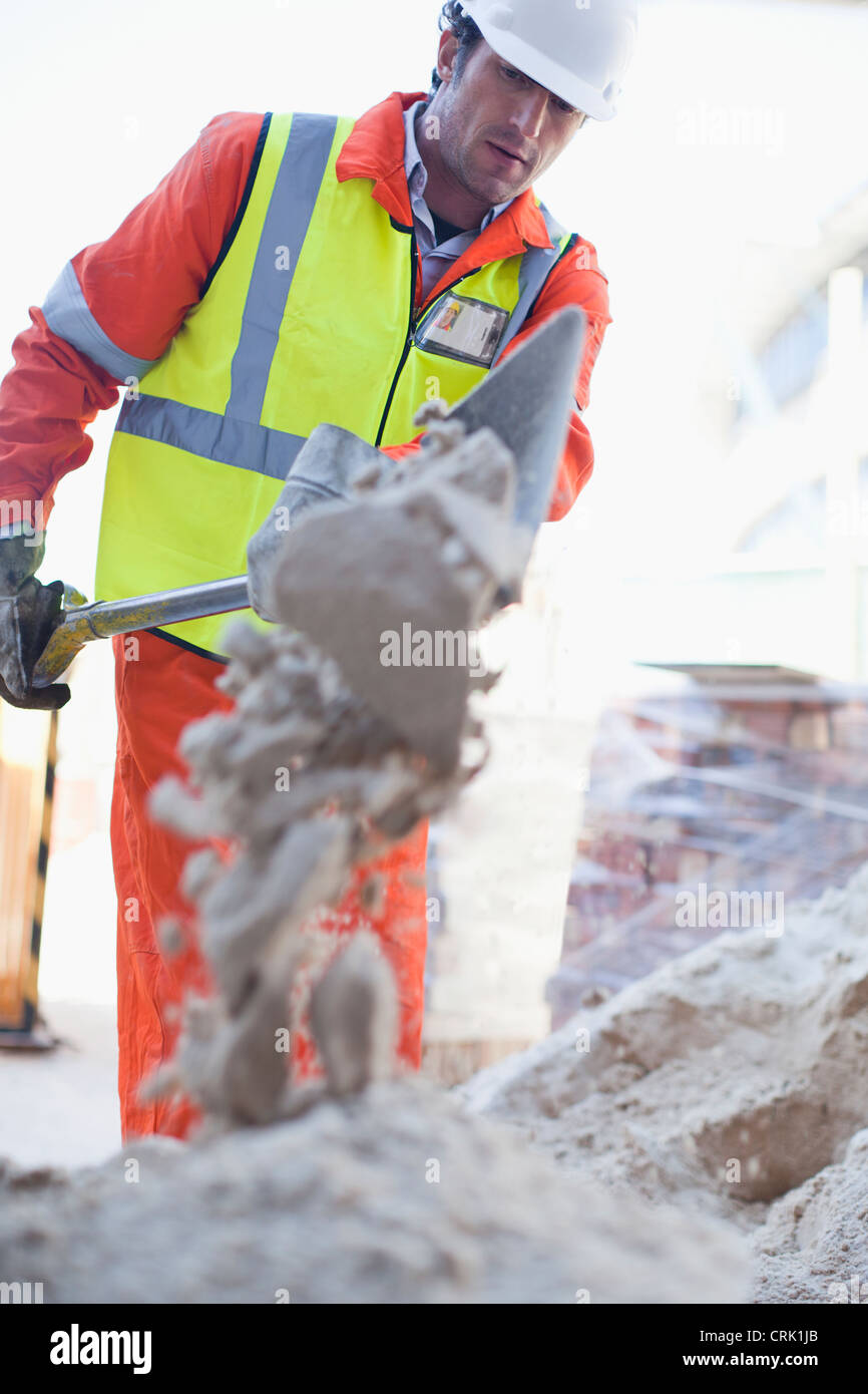 Arbeiter Schaufeln Beton vor Ort Stockfoto