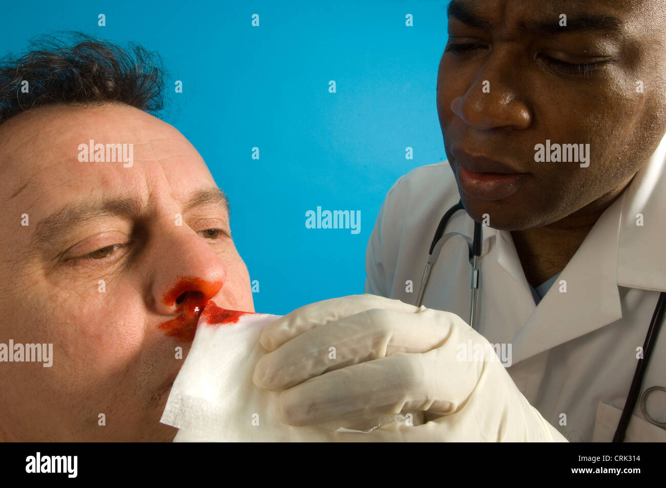 Eine Krankenschwester reinigt blutende Nase des Patienten Stockfoto