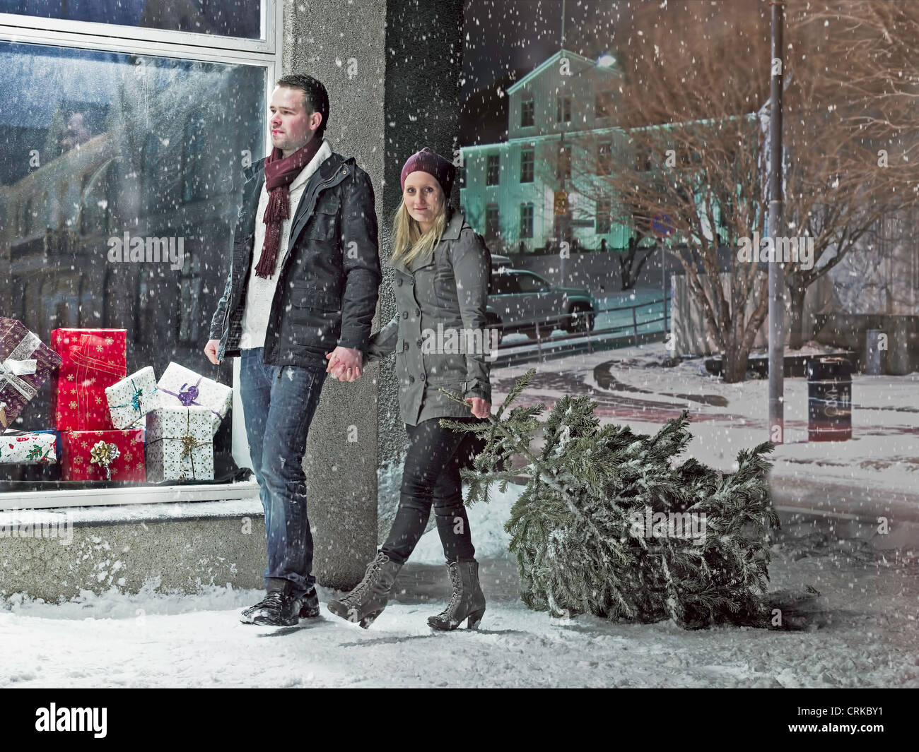 Paar mit Weihnachtsbaum im Schnee Stockfoto