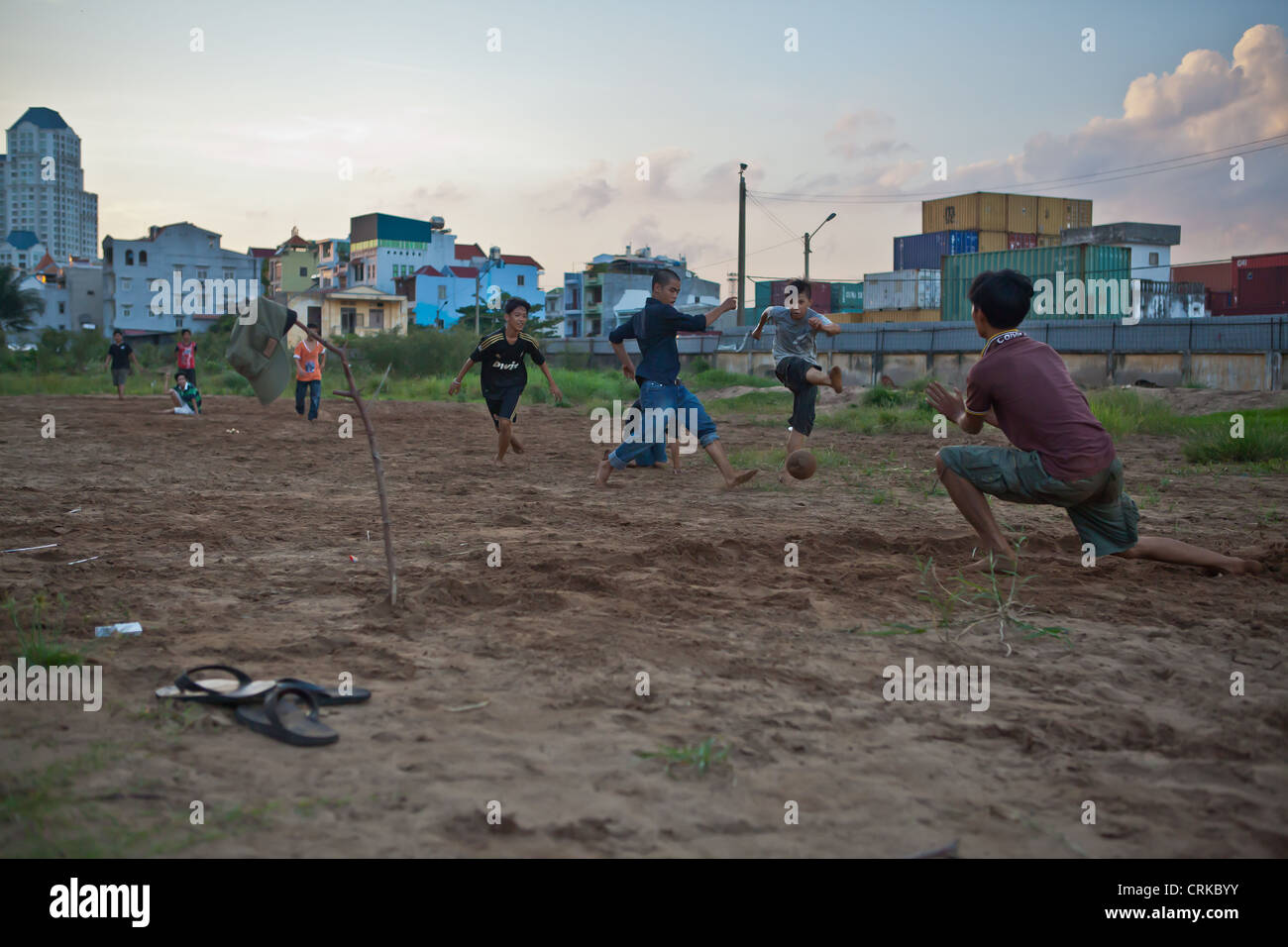 Kinder spielen Fußball in der Nähe von einem Container Park in HCMC, Vietnam Stockfoto