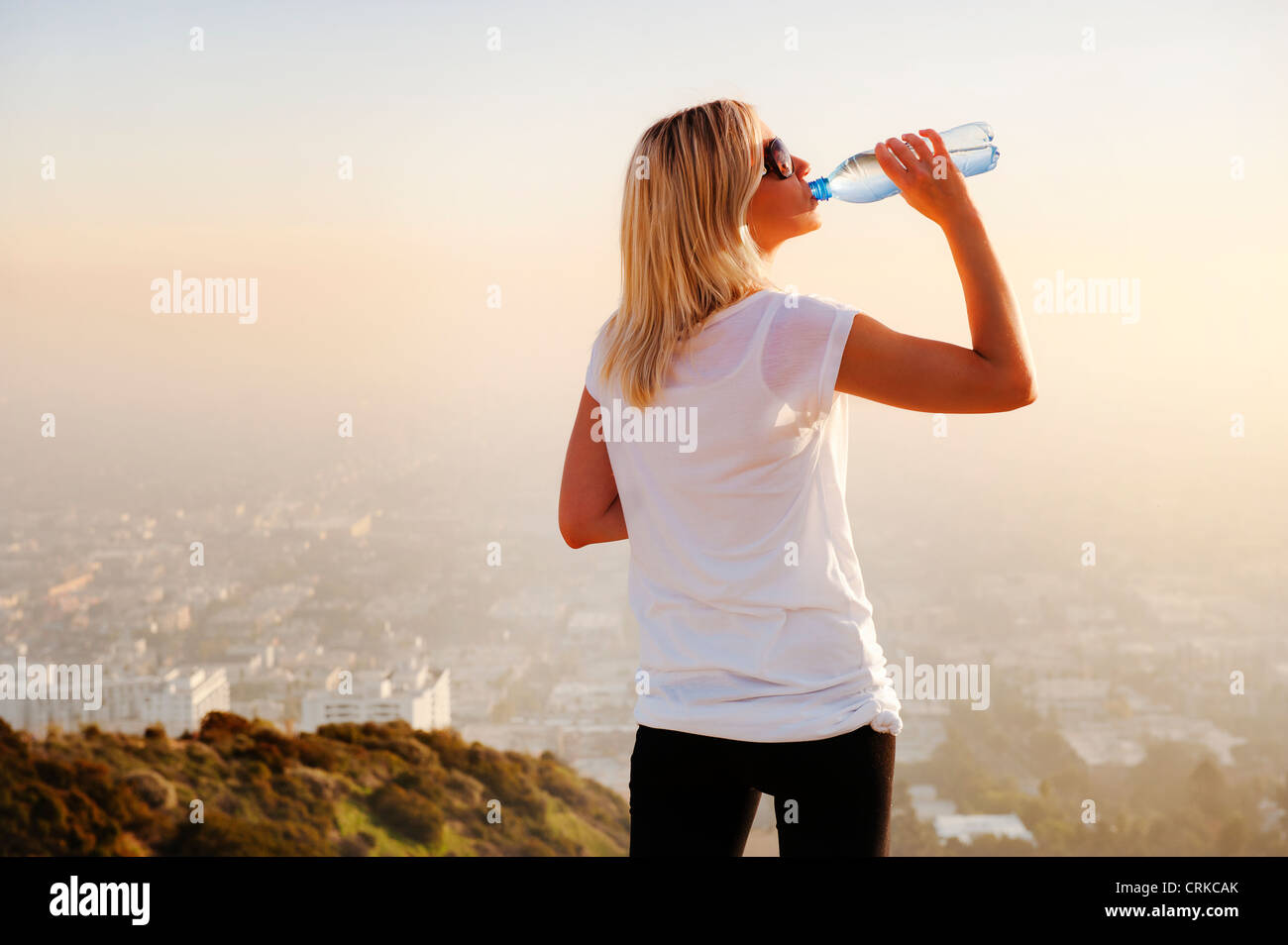 Frau Trinkwasser auf Hügel Stockfoto