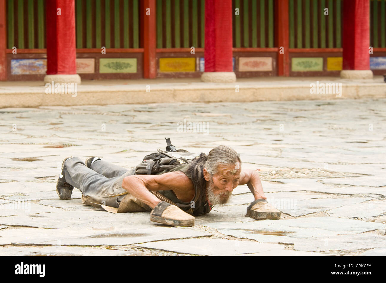 Eine ältere chinesische buddhistisch Pilger in Niederwerfungen an der Klosteranlage Labrang in Xiahe. Stockfoto