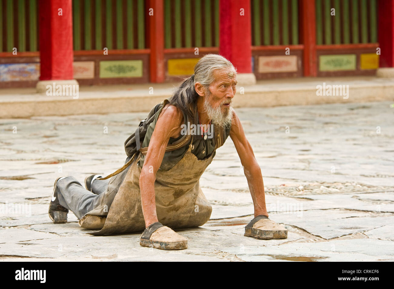 Eine ältere chinesische buddhistisch Pilger in Niederwerfungen an der Klosteranlage Labrang in Xiahe. Stockfoto