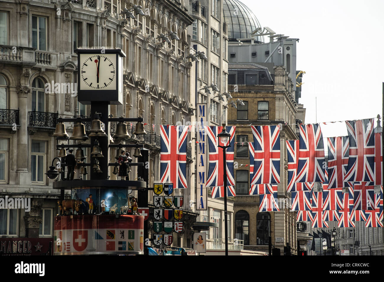 Union Jack-Flaggen hängen über Coventry Street, hinter der berühmten Schweizer Uhr in Leicester Square. Bild von Julie Edwards Stockfoto
