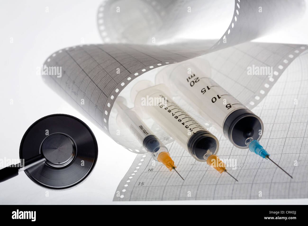 Ein Stethoskop und Injektionen liegen auf einem Elektrokardiogramm auslesen. Stockfoto