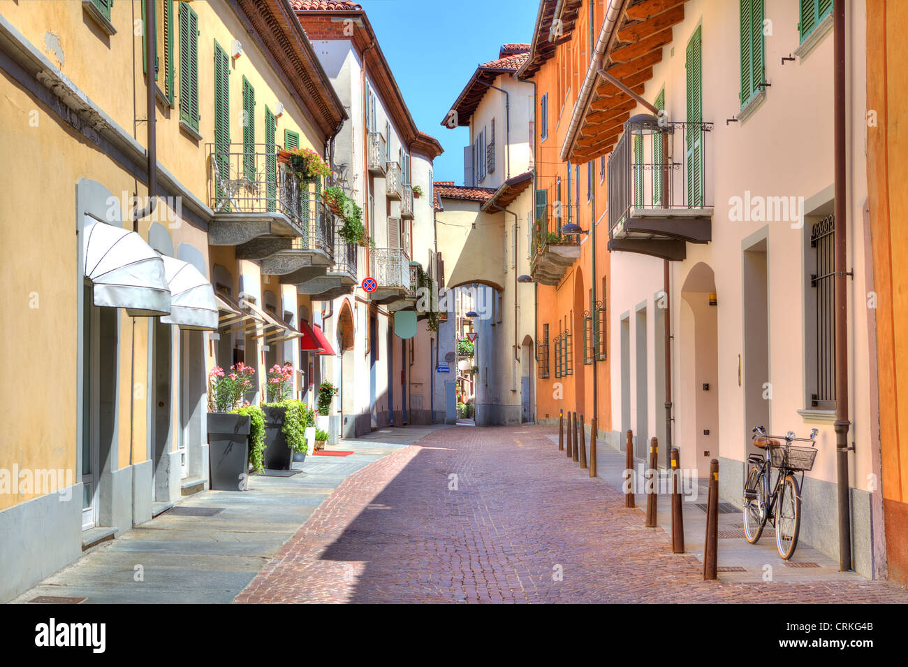 Schmale Stein gepflasterter Straße zwischen bunten Häusern in Stadt von Alba im Piemont, Norditalien. Stockfoto