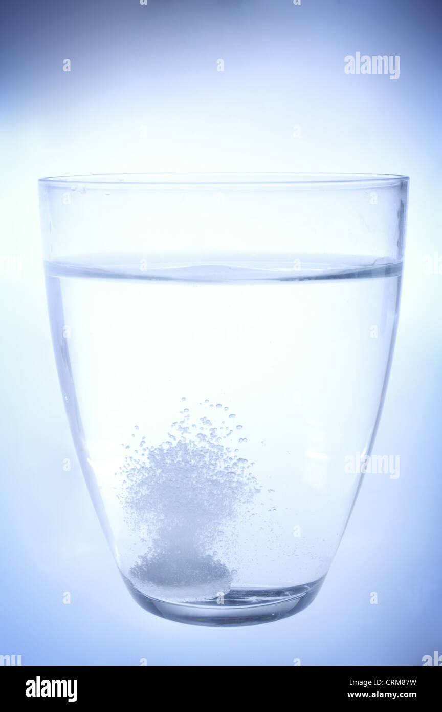 Eine Brausetablette auflöst in einem Glas Wasser. Stockfoto
