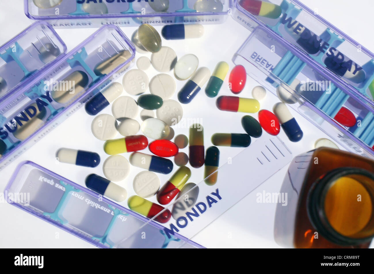 Eine Auswahl von bunten Pillen und Kapseln umgeben von Pille Spenderboxen. Stockfoto