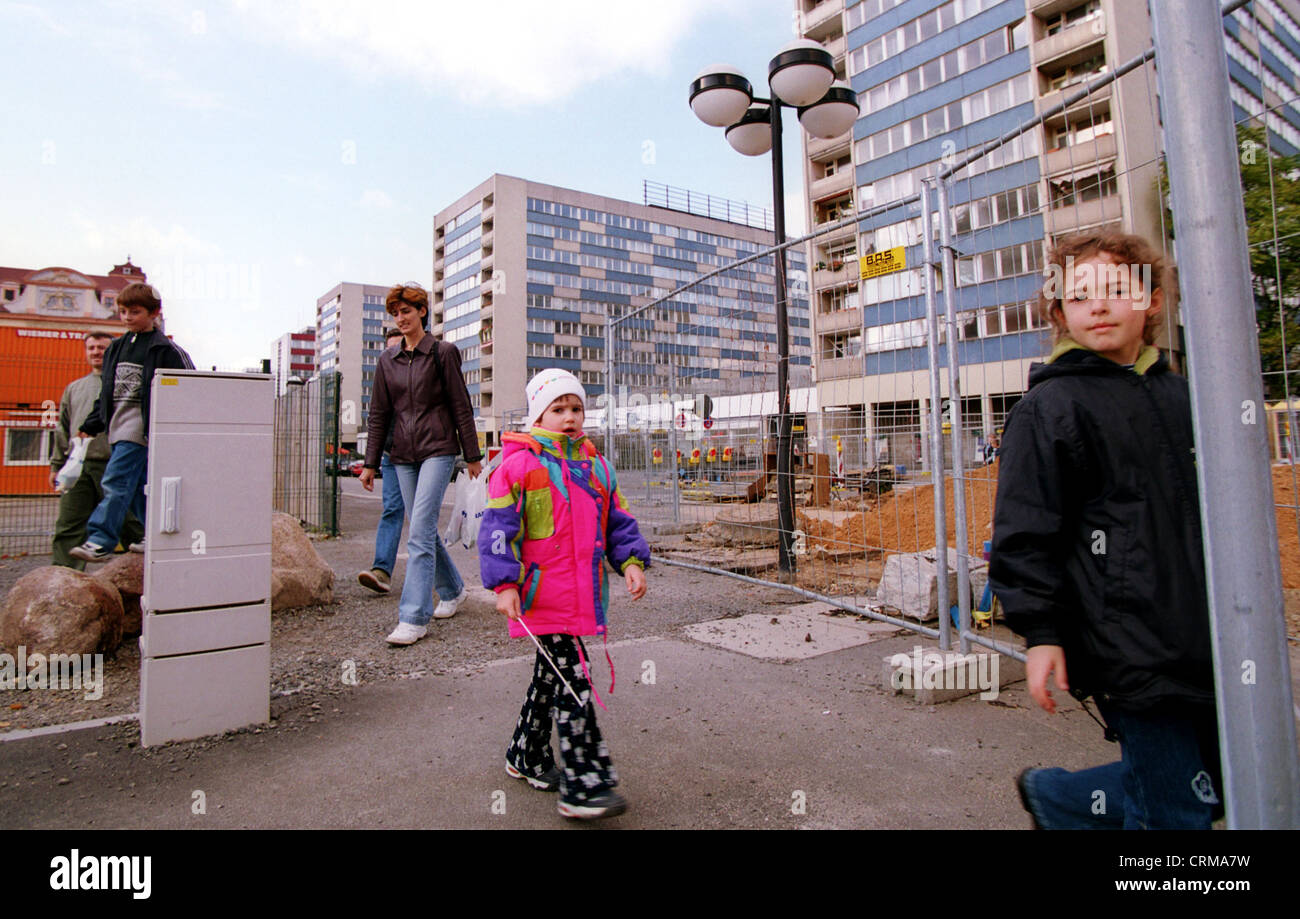 Kinder vor einer Baustelle und Plattenbauten in Leipzig Stockfoto