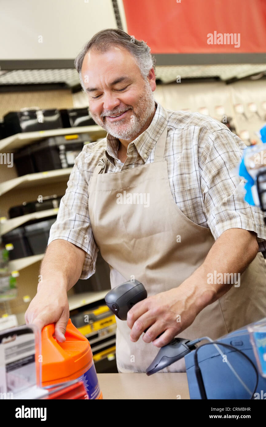 Glückliche ältere Verkäuferin mit Barcode-Lesegerät an Kasse Stockfoto