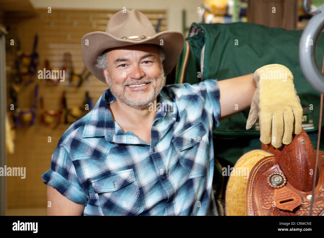 Porträt eines glücklichen Reife Cowboy im feed store Stockfoto