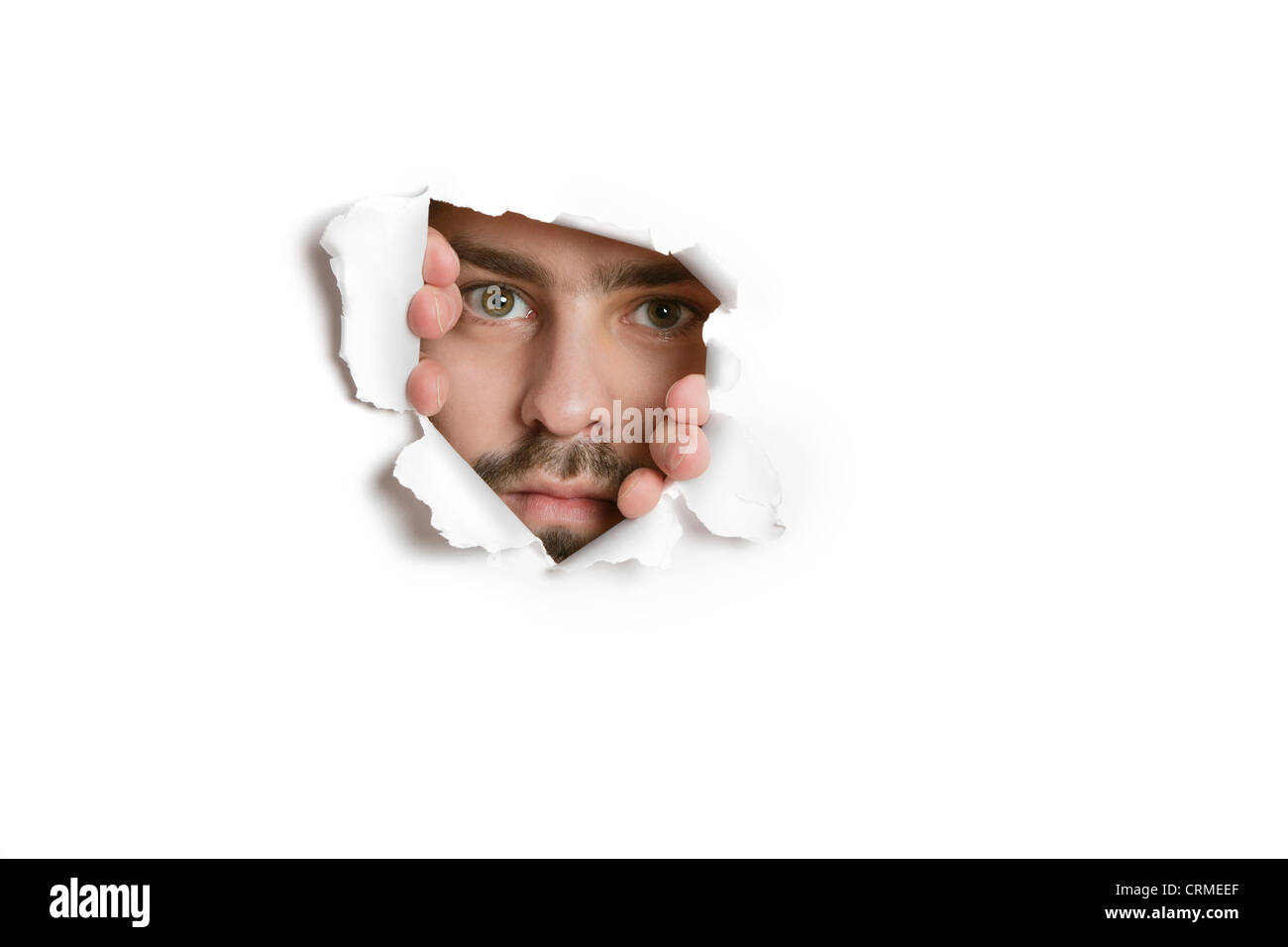 Porträt eines Mitte Erwachsene kaukasischen spähen aus gerippten Papier Loch Stockfoto