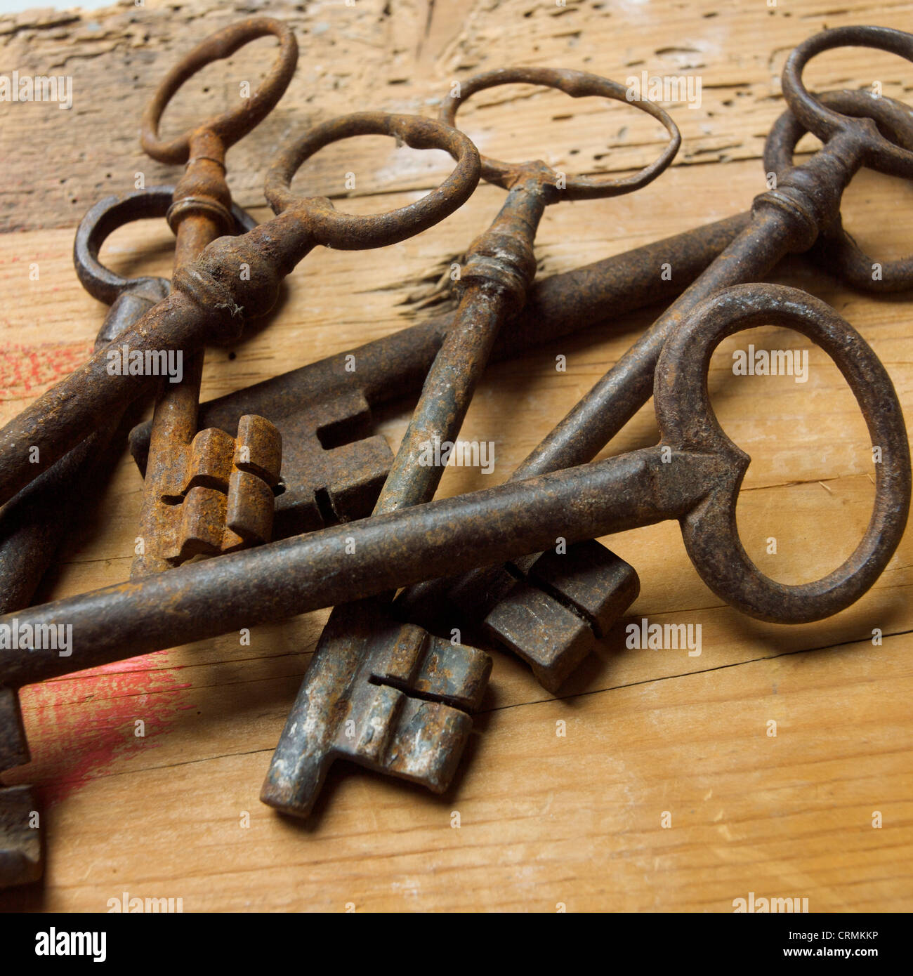 Alte Schlüssel auf hölzerner Oberfläche zeigen komplizierte Vintage-Designs und verwitterte Texturen Stockfoto
