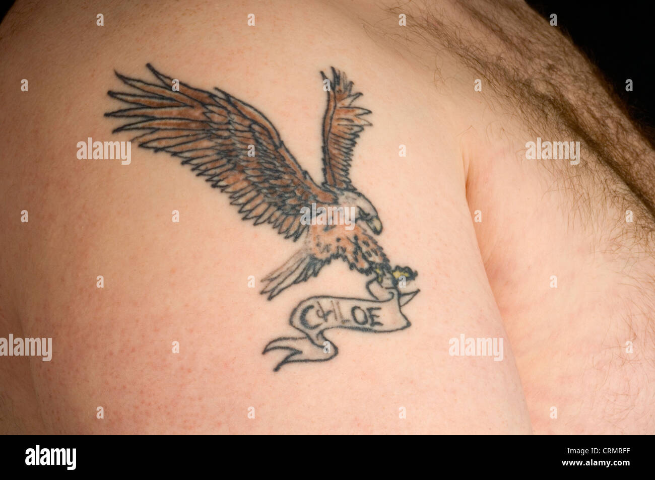 Nahaufnahme von einem Adler Tattoo mit Chloe Name auf dem Arm eines Mannes. Stockfoto