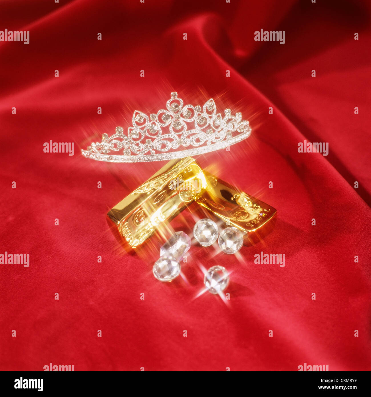 Glitzernde Goldbarren, Diamanten und Tiara auf Granat samt Stockfoto