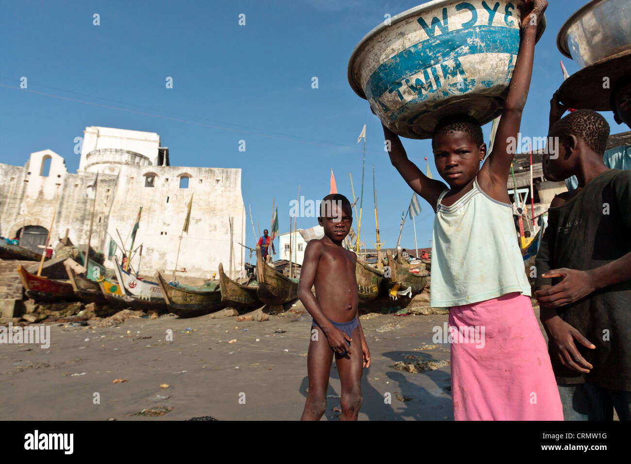 Mädchen tragen Container auf dem Kopf in der Nähe von Cape Coast Castle, Cape Coast, Ghana Stockfoto