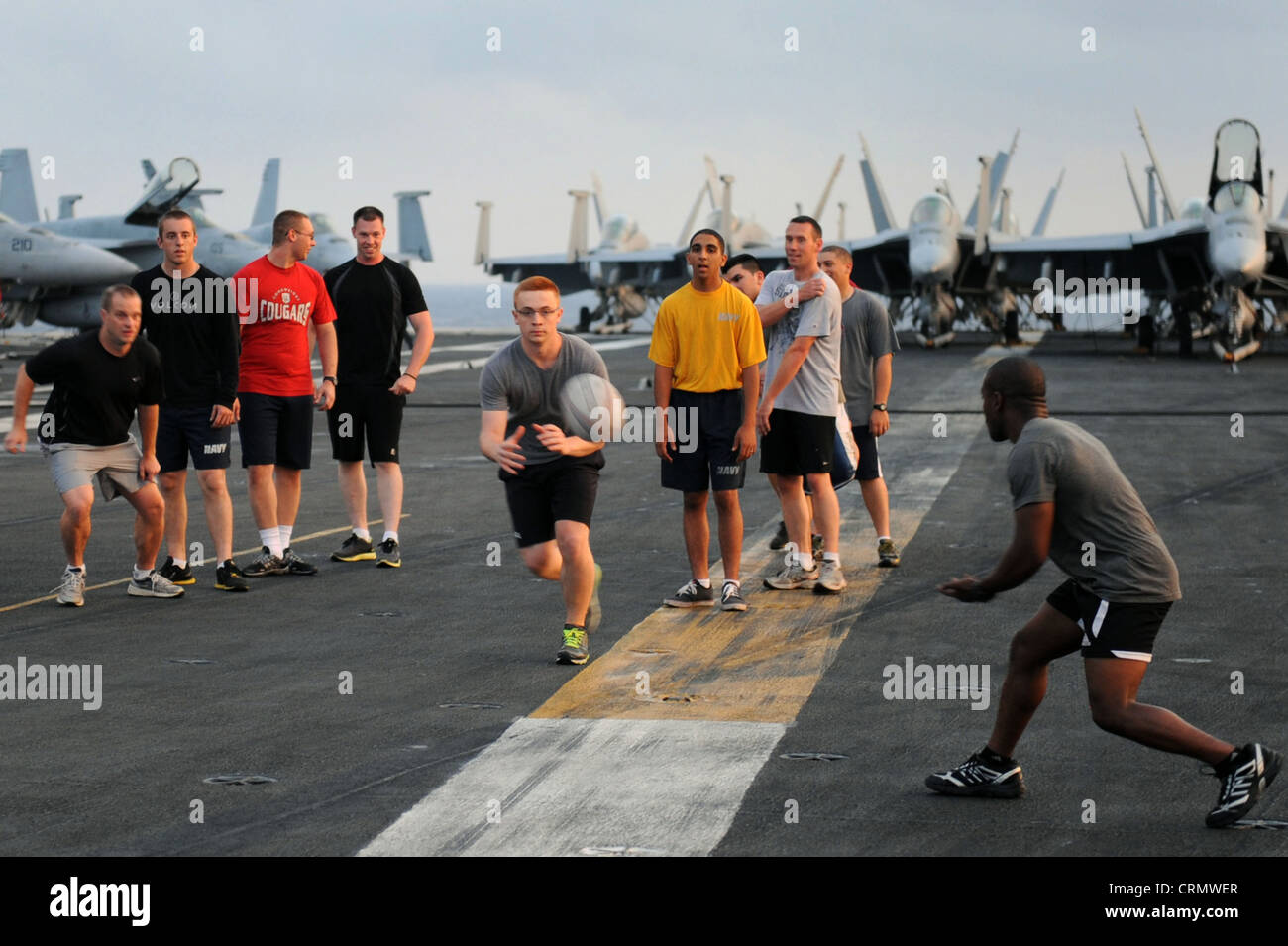 Das Rugby-Team der Nimitz-Klasse USS Dwight D. Eisenhower (CVN 69), die IKE Mauler, trainiert auf dem Flugdeck für ihr ankommendes Spiel. Dwight D. Eisenhower ist in einem geplanten Einsatz zur Unterstützung der maritimen Sicherheitsoperationen und der Zusammenarbeit im Bereich der Theatersicherheit in den Verantwortungsbereichen der 5. Und 6. Flotte der USA. Stockfoto