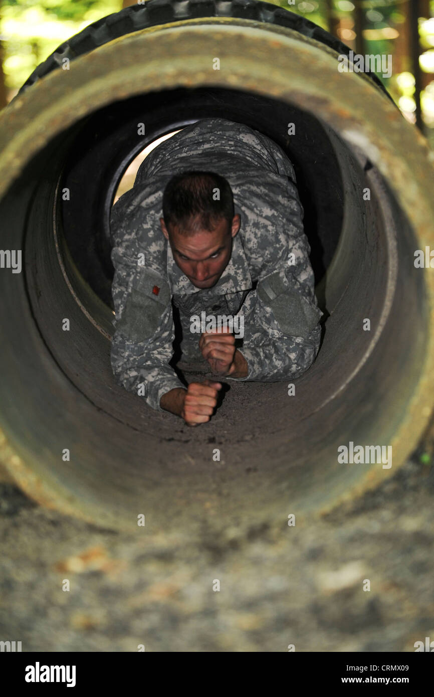 U.S. Army Staff Sgt. Jarod Moss, Bohreroffizier der 95. Reserve Division, kriecht auf dem Confidence Course in Fort Eustis, VA., im Rahmen des jährlichen Drill Sergeant of the Year Wettbewerbs, der vom Initial Military Training, U.S. Army Training and Doctrine Command, 27. Juni 2012, ausgerichtet wird, durch das Tunnelhindernis. Während des Kurses mussten die Teilnehmer Dinge wie tun; niedrige Kriechgang, Kreuz Affenbarren, klettern Wände und springen Gräben. Stockfoto