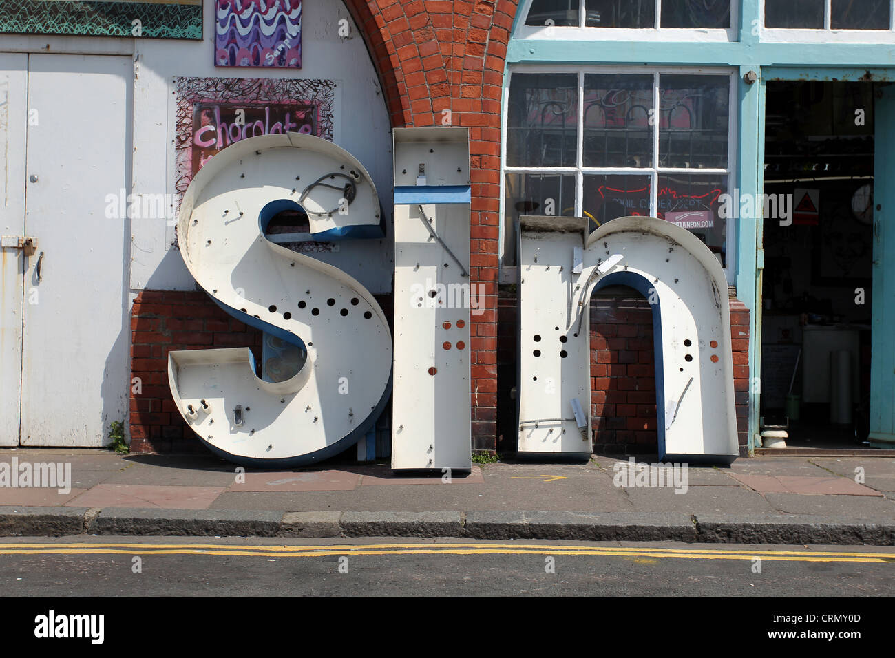 Ein Vintage Schild mit der Aufschrift "Sünde" im Bild außerhalb einer unabhängigen Werkstatt in Brighton, East Sussex, UK. Stockfoto