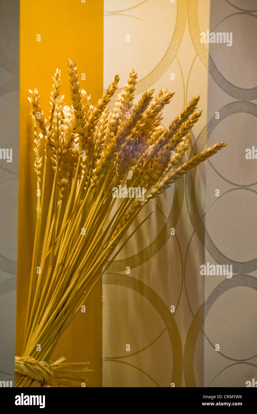 Dekorative Vase von Weizen gegen Tapete Stockfoto