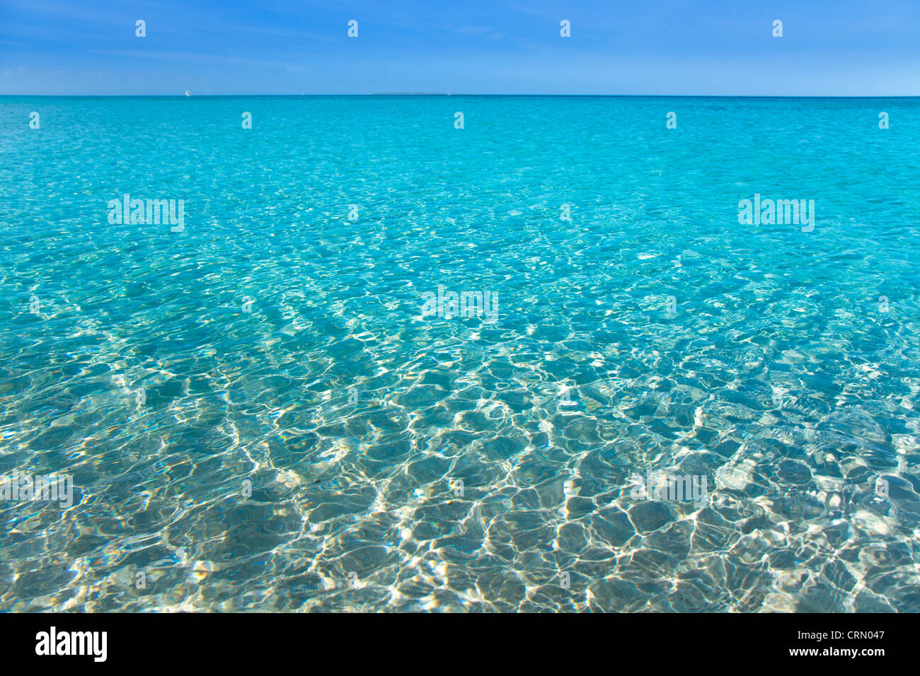 Strand mit weißem Sand und türkisfarbenem Wasser unter blauem Himmel tropische Stockfoto