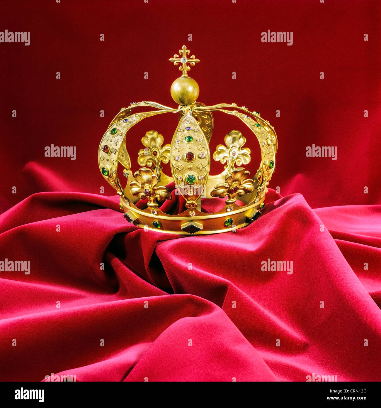 Goldene Krone mit Diamanten auf Granat samt Stockfoto
