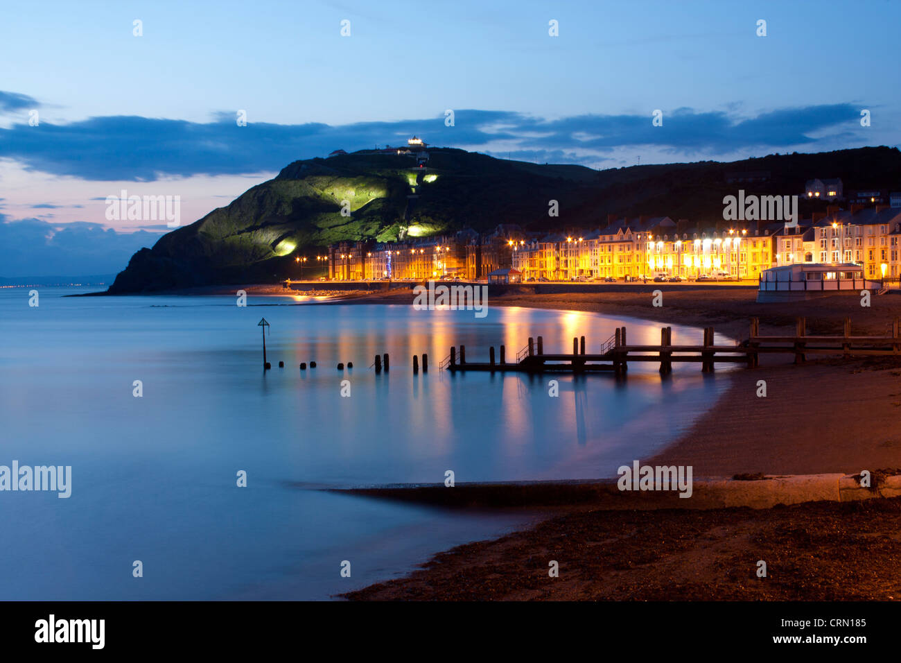 Blick auf Marine Terrace Promenade, Strand und Constitution Hill in der Dämmerung / Nacht Aberystwyth Ceredigion Mid Wales UK Stockfoto