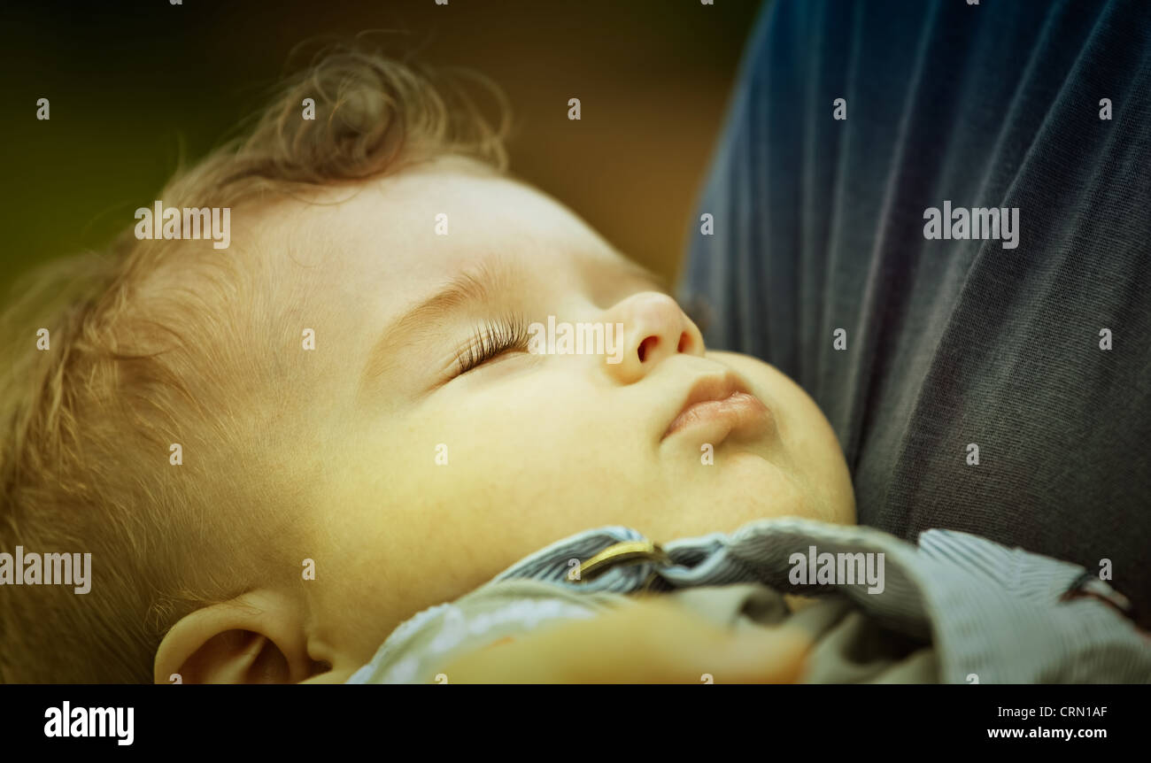 Porträt von glücklichen kleinen Jungen schlafen friedlich in den Armen Mutter. Stockfoto