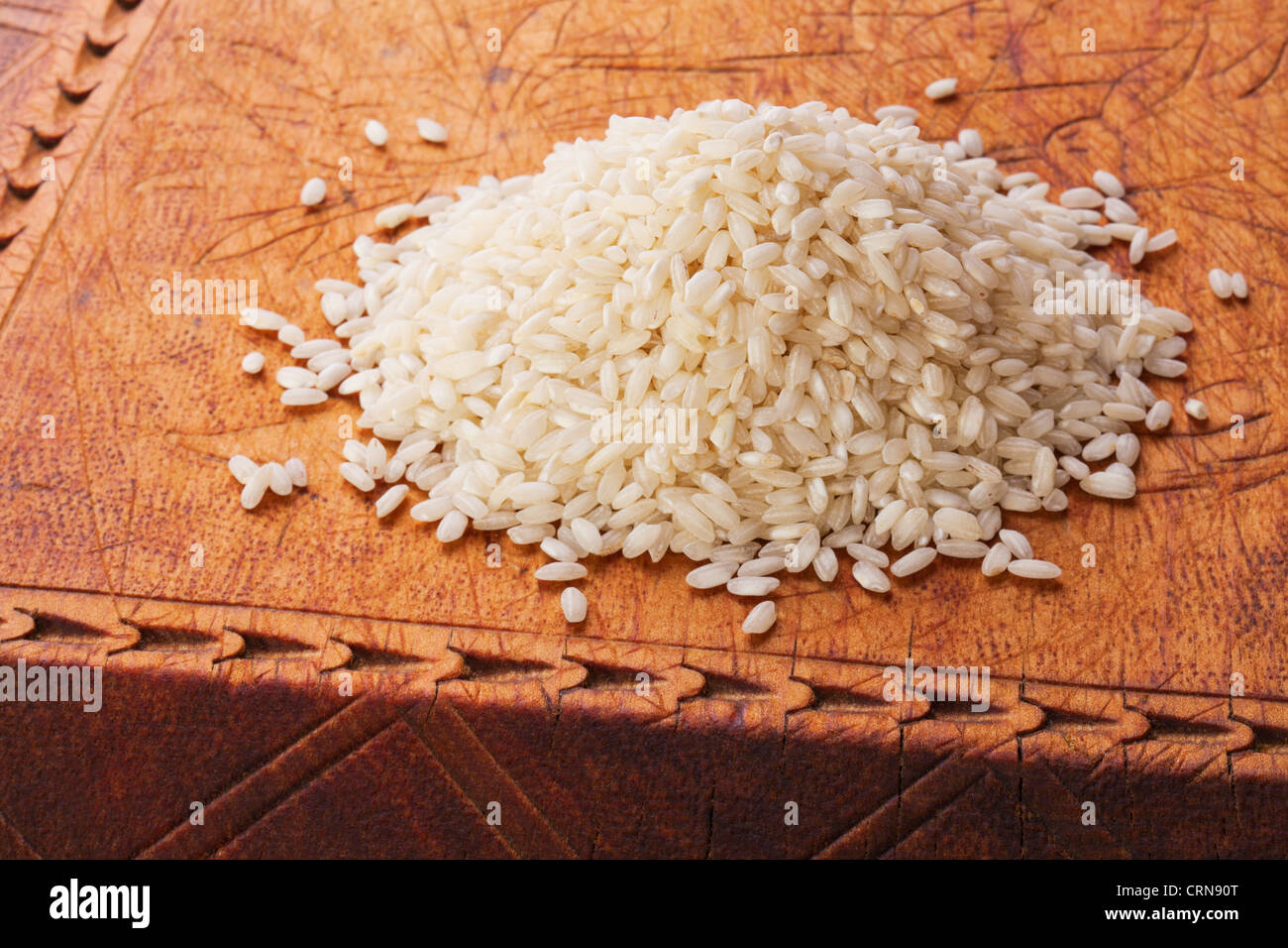 Carnaroli-Reis für Risotto, auf einem alten Holzbrett in der Regel verwendet. Stockfoto