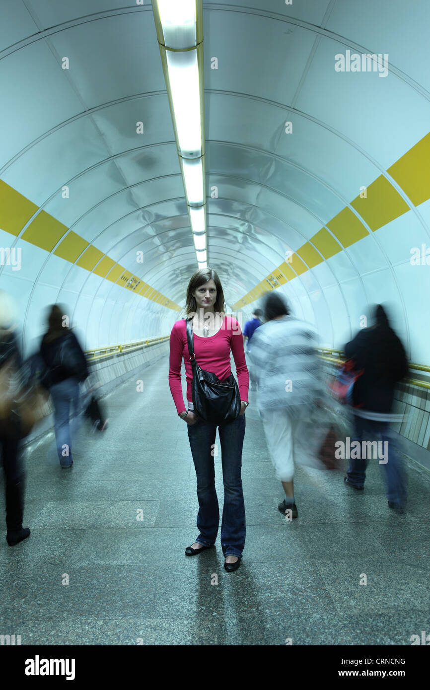 U-Bahn - junge Frau in einem u-Bahn-Korridor während der Masse der Pendler vergeht Stockfoto