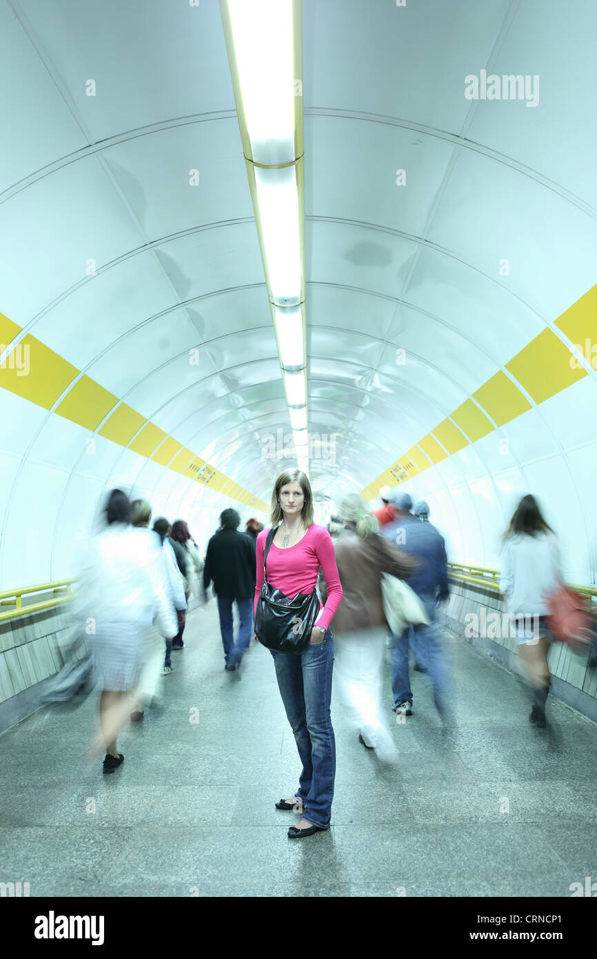 U-Bahn - junge Frau in einem u-Bahn-Korridor während der Masse der Pendler vergeht Stockfoto