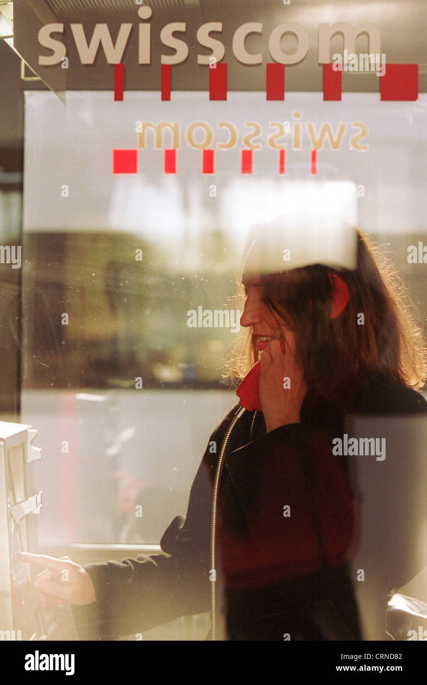 Eine Frau steht in einer Telefonzelle der Schweizer Telekommunikationsgesellschaft Swisscom Stockfoto