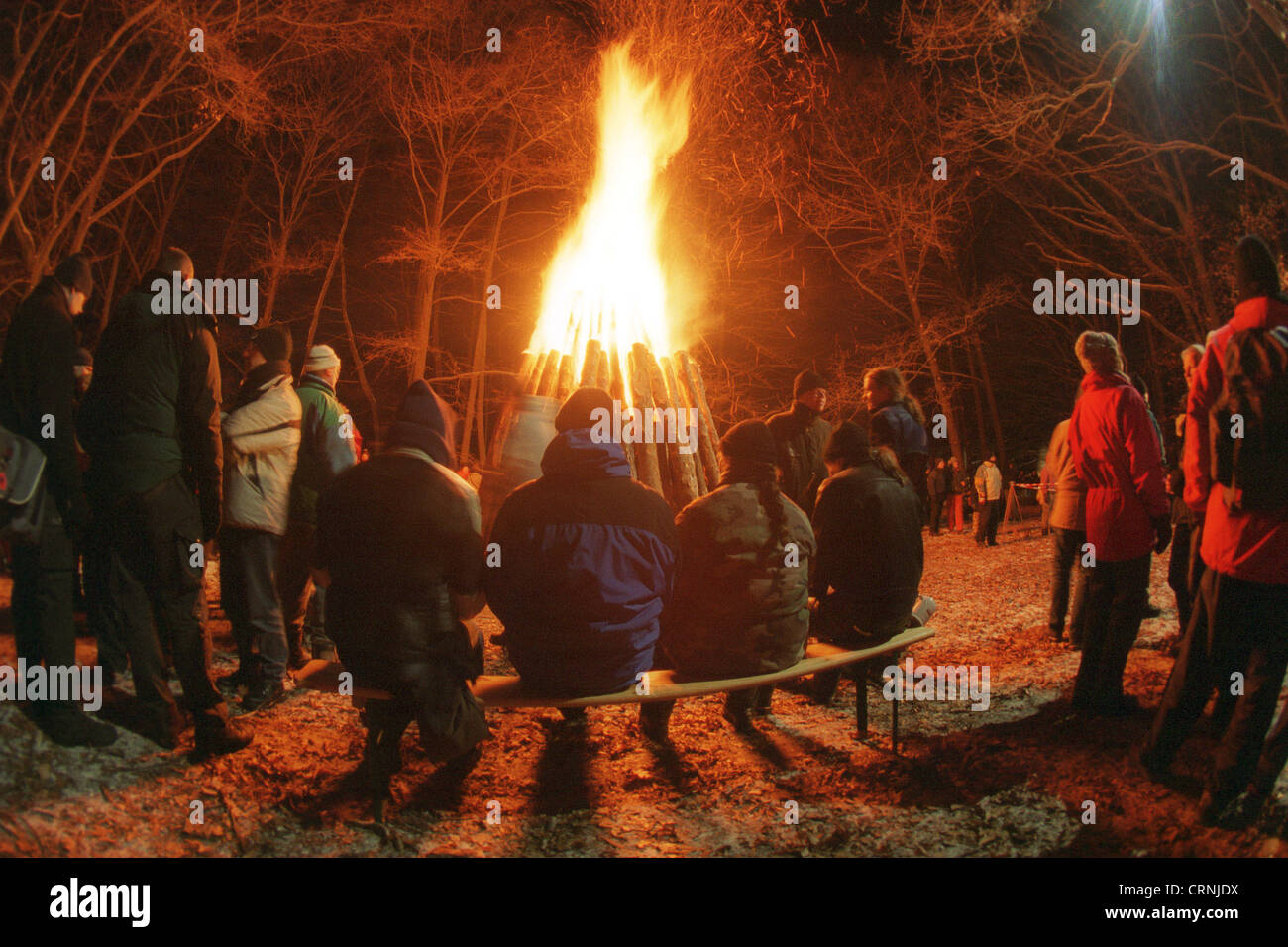 Menschen um ein Lagerfeuer beim Feiern Stockfoto