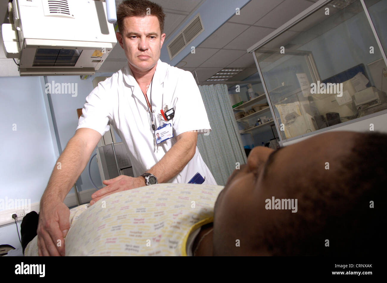 Ein Radiologe, Vorbereitung eines Patienten auf eine Röntgenaufnahme unter der Maschine. Stockfoto