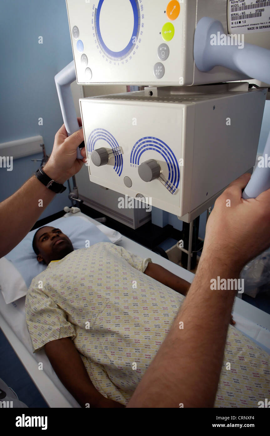 Ein Radiologe, Vorbereitung einen Patienten unter einem Röntgengerät. Stockfoto