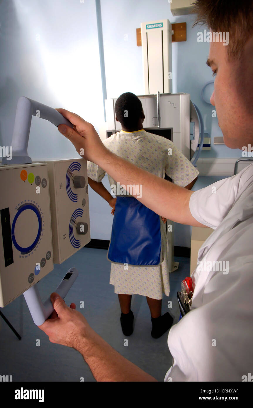 Ein Radiologe Röntgen einen männlichen Patienten, die vor dem Röntgengerät steht. Stockfoto