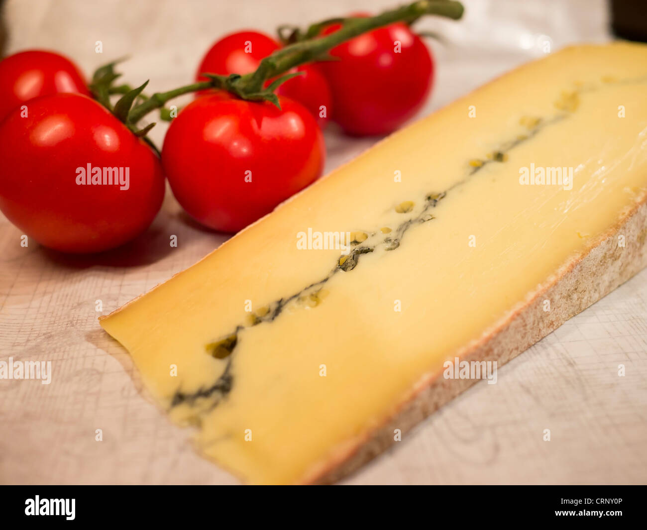 Eine Scheibe von Morbier-Käse und ein paar reife Tomaten. Morbier ist ein semi-soft Kühe Milchkäse aus Frankreich. Stockfoto