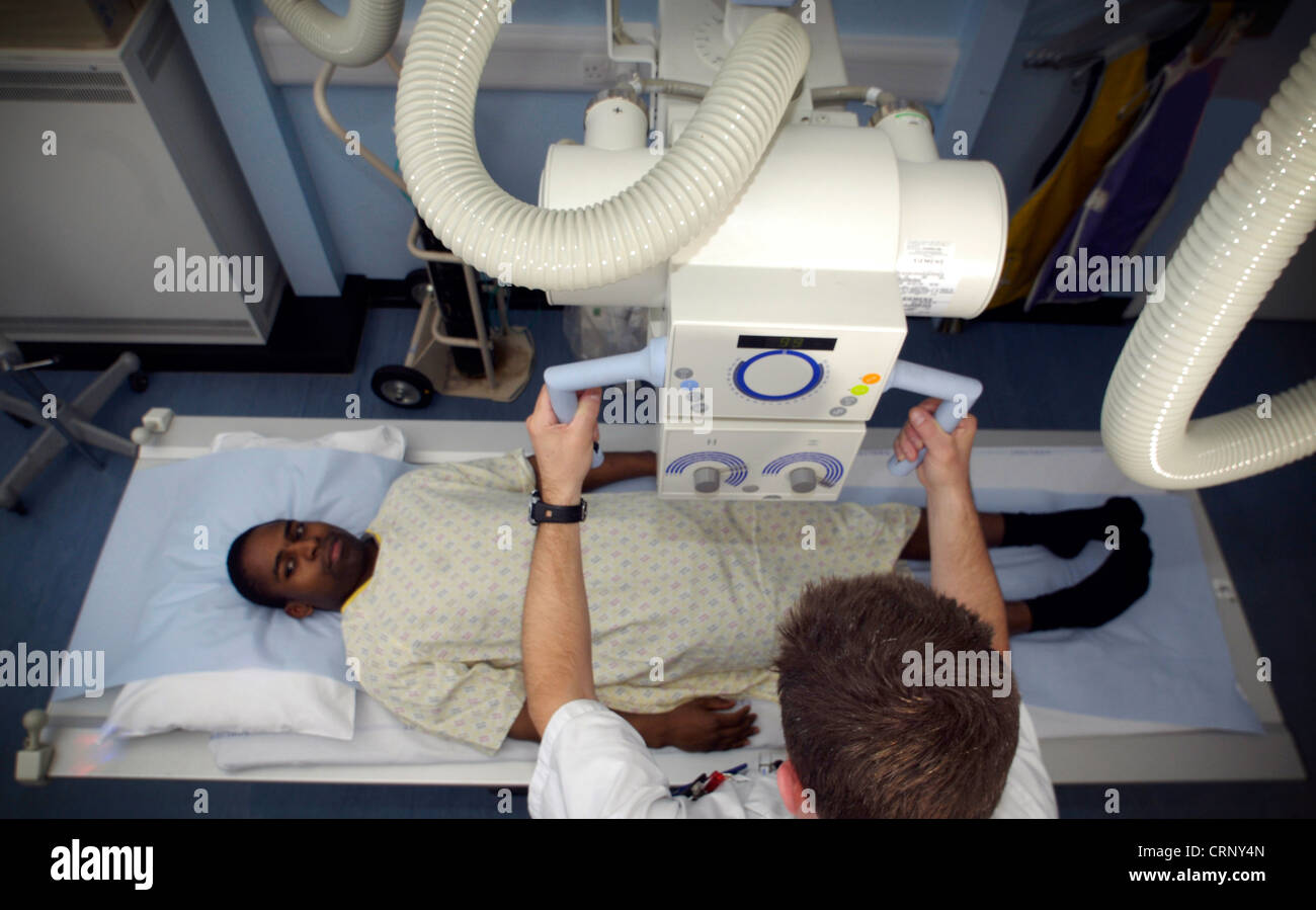 Ein Radiologe, Vorbereitung einen Patienten unter einem Röntgengerät. Stockfoto