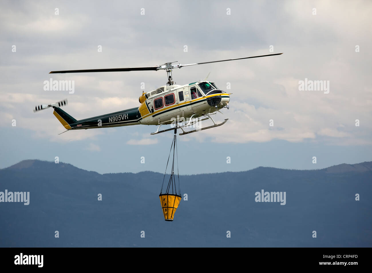 Hubschrauber Luftaufnahmen Wald kämpfen Flugzeug Eimer mit Wasser aus kleinen Teich zu fallen auf Flammen und Hot Spots zu füllen. Stockfoto