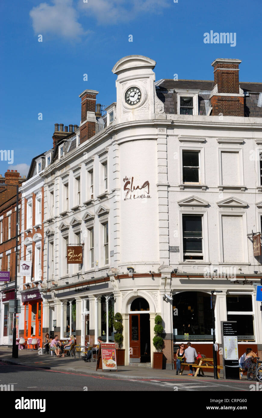 Menschen sitzen vor der Schnecke und Salat Pub an der Ecke der Upper Street und Islington Green. Stockfoto