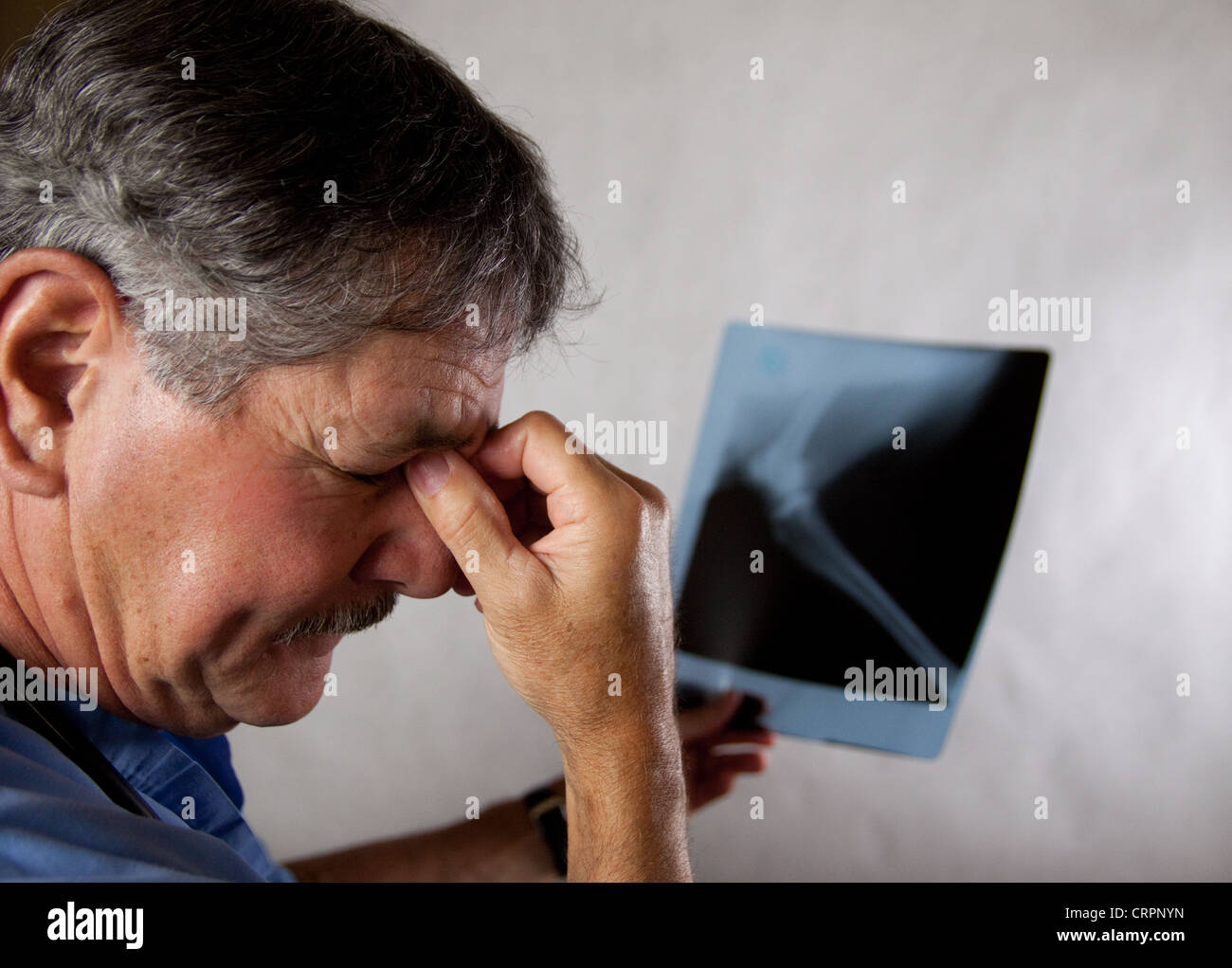 Arzt in Scrubs eine Röntgenaufnahme überprüfen Stockfoto