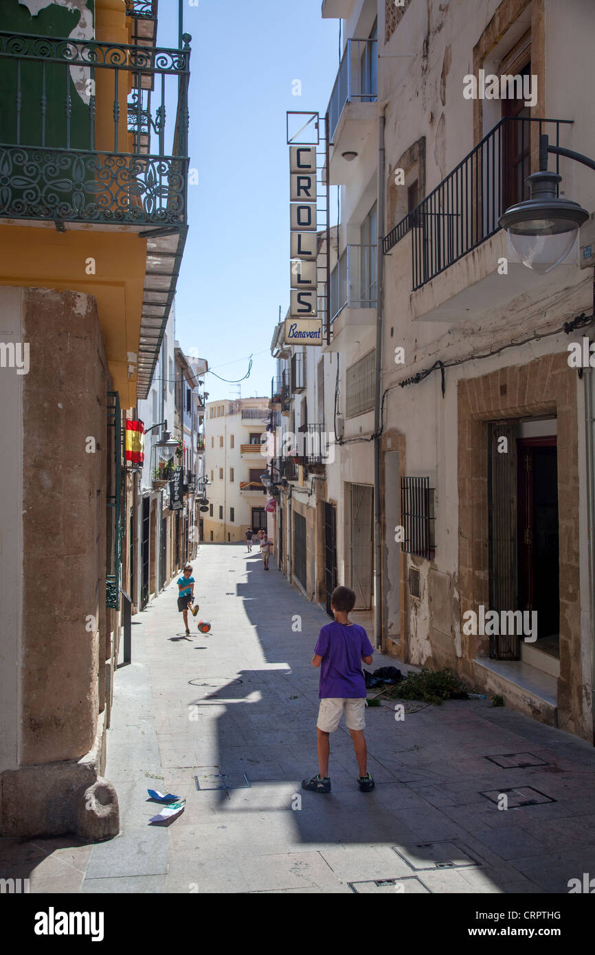 Jungen spielen Fußball in einer engen Straße in Javea, Spanien. Stockfoto